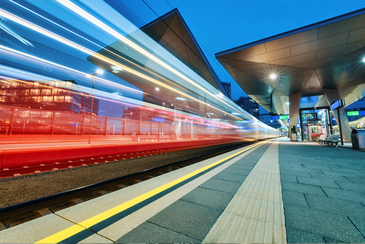 Zug fährt durch Bahn-Station mit Bewegungseffekt.