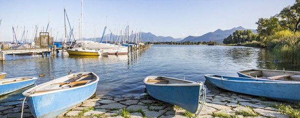 Chiemsee - Boote am Ufer mit Blick auf die Berge.