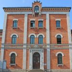 Historisches Backsteingebäude mit Rundbogenfenstern.