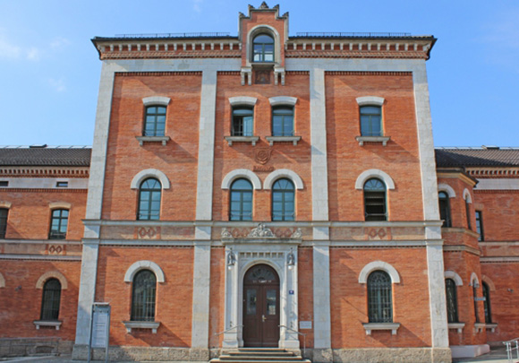 Historisches Backsteingebäude mit Rundbogenfenstern.