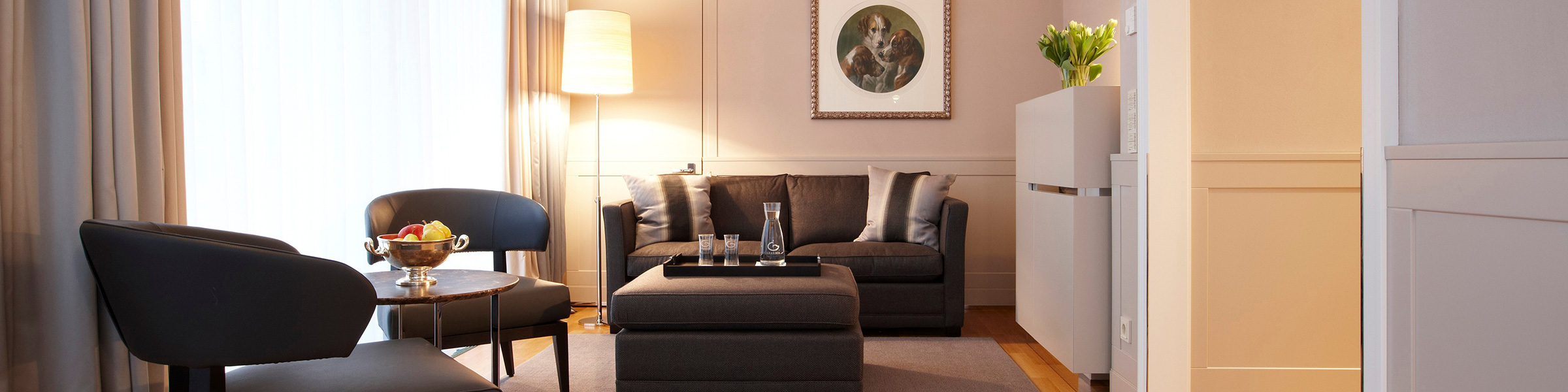 Modernes Wohnzimmer mit dunkler Couch und stilvollen Lesesesseln.