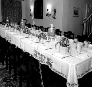 Schwarz-weiß Bild einer festlichen Veranstaltung mit gedecktem Tisch.