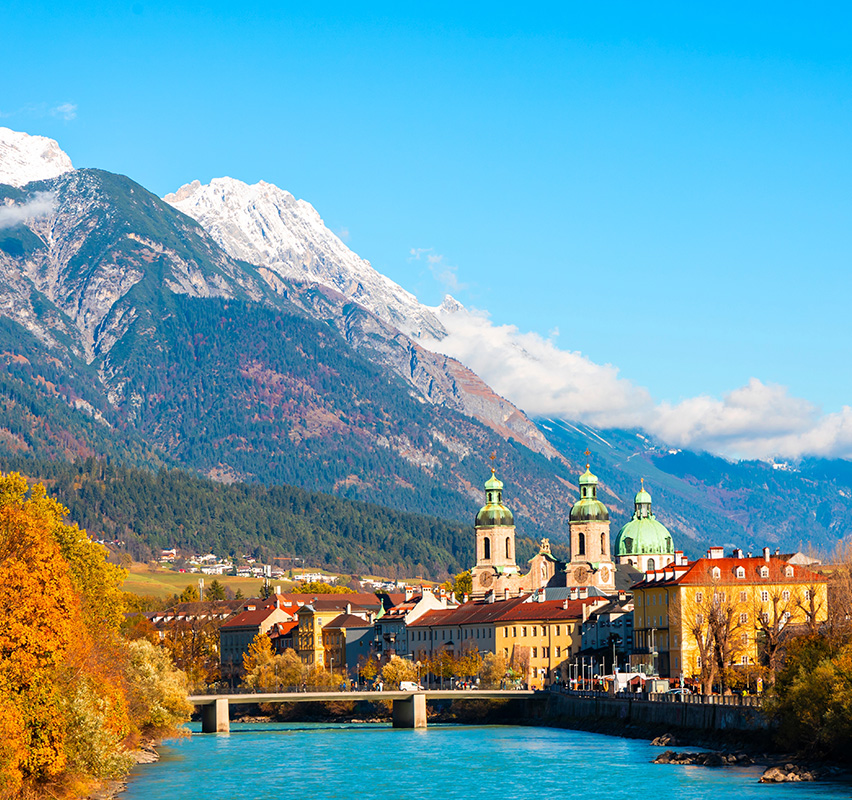 Blick über Innsbruck mit Inn-Fluss und schneebedeckten Bergen.