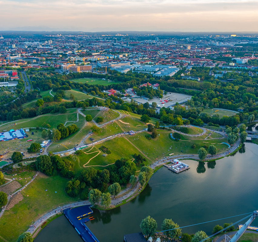 Blick über Olympiapark München mit Stadion und Grünflächen.