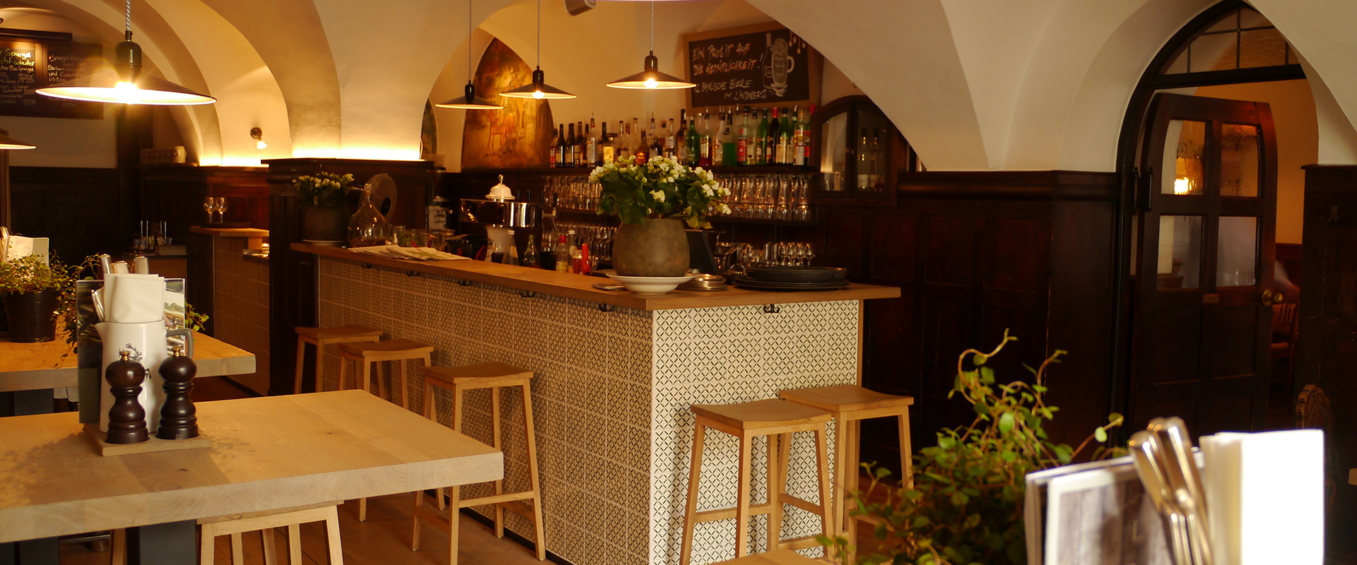 Restaurant Schwemme mit Barbereich mit Tresen, Sitzhockern und Spirituosenregal.