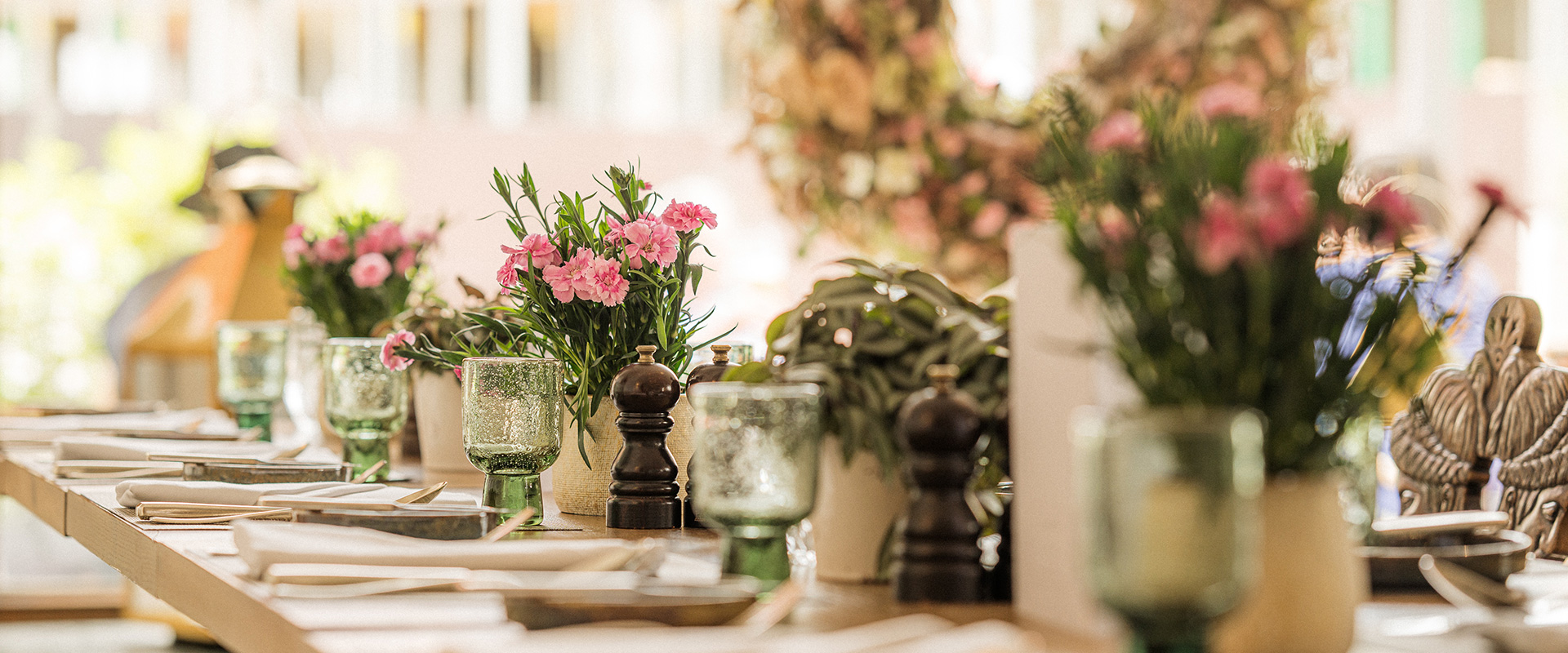 Nahaufnahme eines gedeckten Tisches im Restaurant Schwemme mit floraler Dekoration.