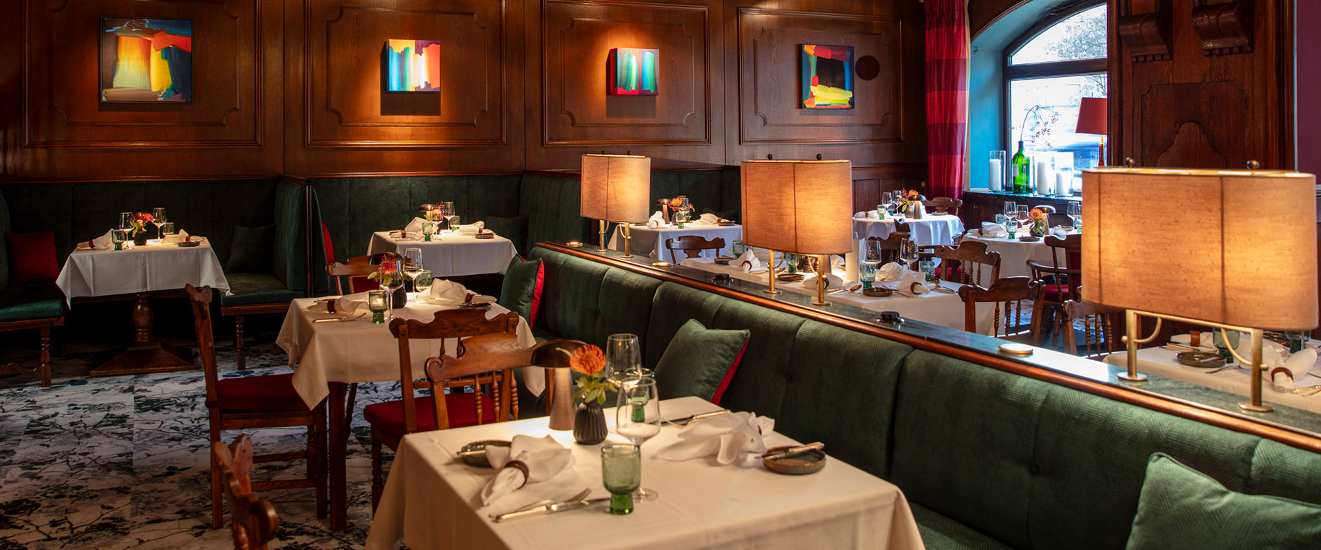 Restaurant Lindners Stub'n mit elegant gedeckten Tischen und Holzverkleidung.