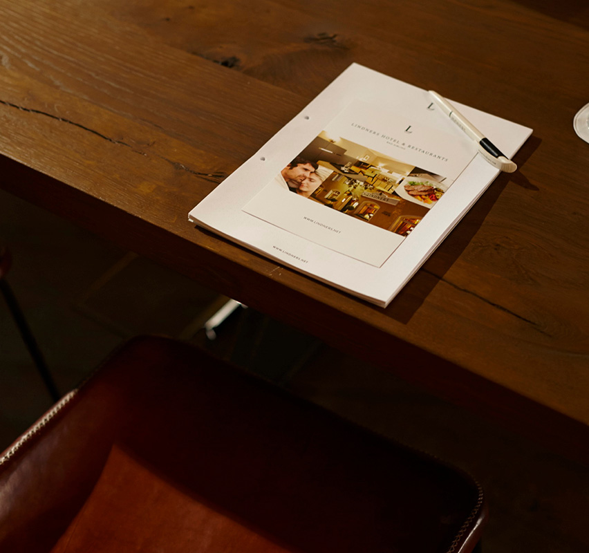 Broschüre oder Heft auf einem Tisch liegend mit Kugelschreiber, Tagungen im Weinkeller