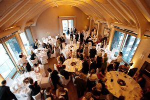 Hochzeit oder Feier mit runden Tischen und weißen Stuhlhussen im Lindners Stad’l