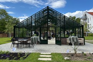 Großes modernes Glashaus in ländlicher Umgebung.