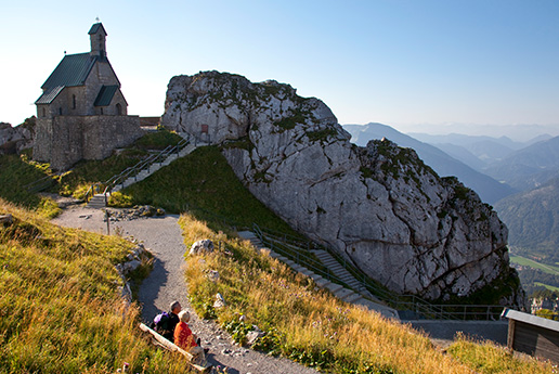 Wanderer auf einem Bergrücken mit weitem Ausblick ins Tal.