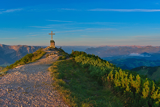 Wanderweg entlang einer felsigen Gebirgskante mit Aussicht.