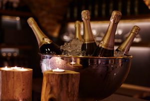 Flaschenkühler mit mehreren Flaschen Champagner und Wein, bereit für ein Event.