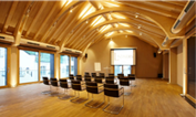 Lindners Stadl mit aufgereihten Stühlen und großer Leinwand für Konferenzen oder Tagungen.