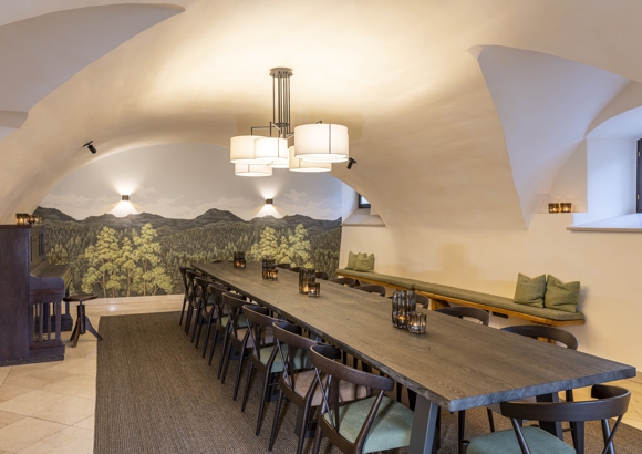 Tagungsraum mit modernen Stühlen und Gewölbedecke vor Motivtapete mit Wald - Schlosskeller