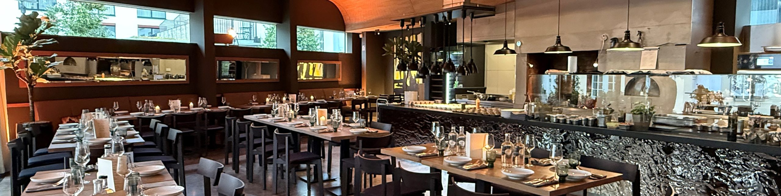Modernes Restaurant Waage in Bad Aibling mit stilvollem Gastraum, offener Grillküche und gedeckten Tischen.