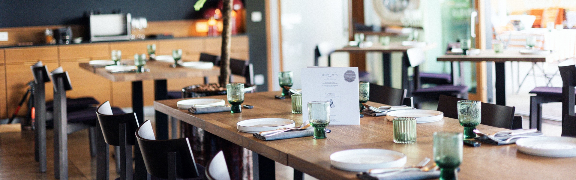 Gedeckter Holztisch im Restaurant Lindners Waage mit modernen Tellern und Gläsern.