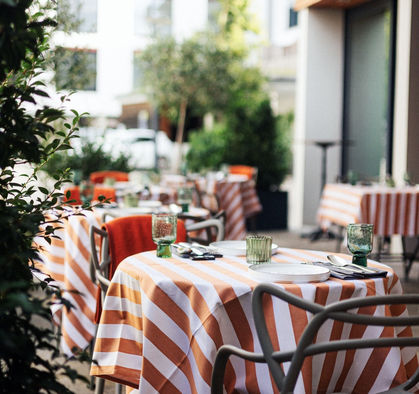 HotelLindner_Waage06_800 Terrasse vom Restaurant Lindners Waage mit gedeckten Tischen und gestreifter Tischdecke